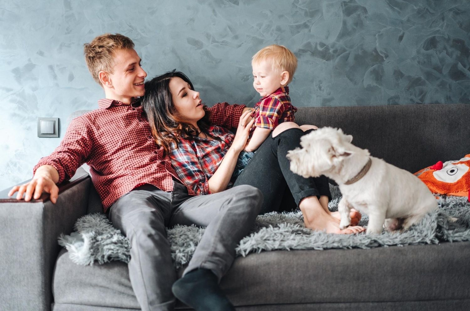 Happy couple unpacking from move, with their pet dog